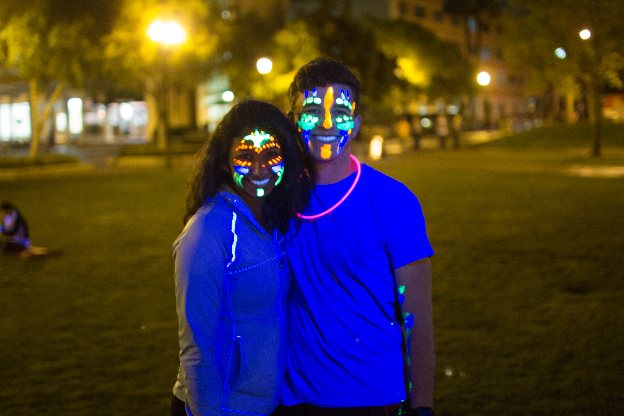 students with glow in the dark face pain posing