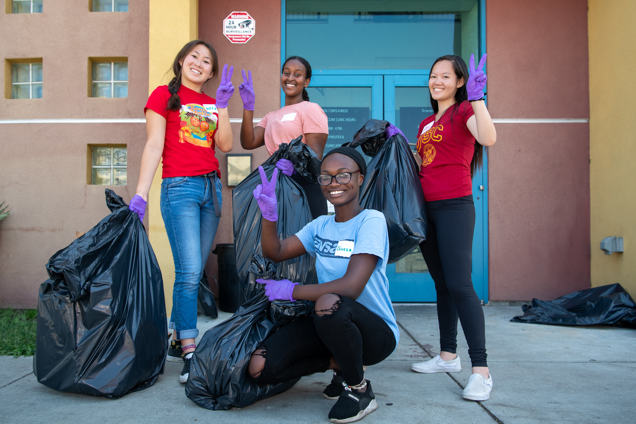 volunteer students with garbage bags throwing USC fight on symbol