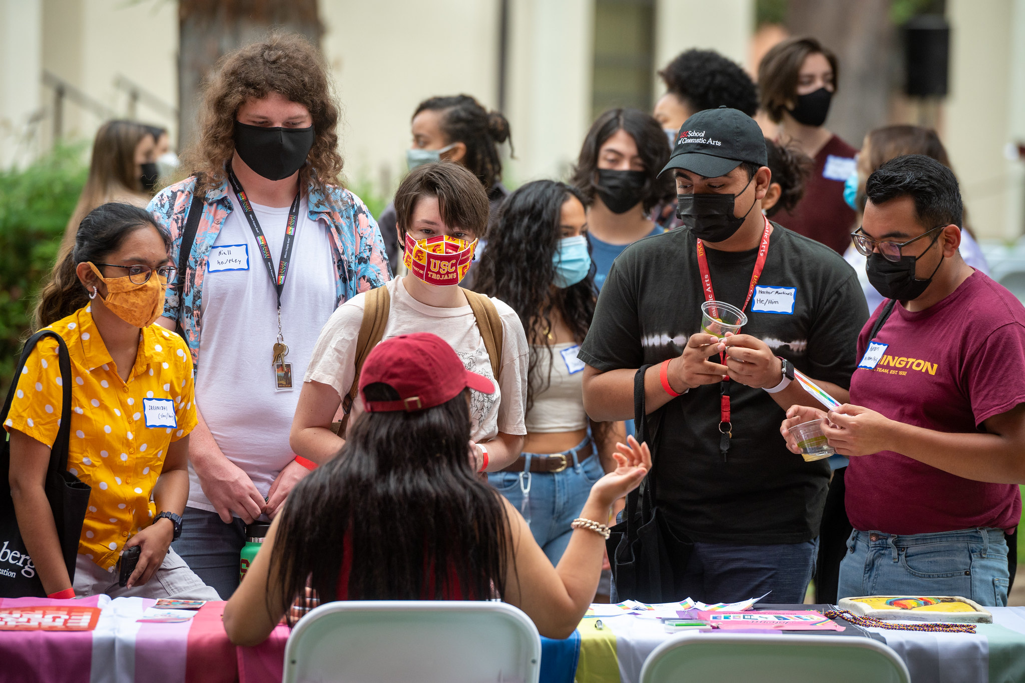 masked students speaking worker at table